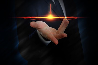 Image of Businessman holding digital target against dark background, closeup