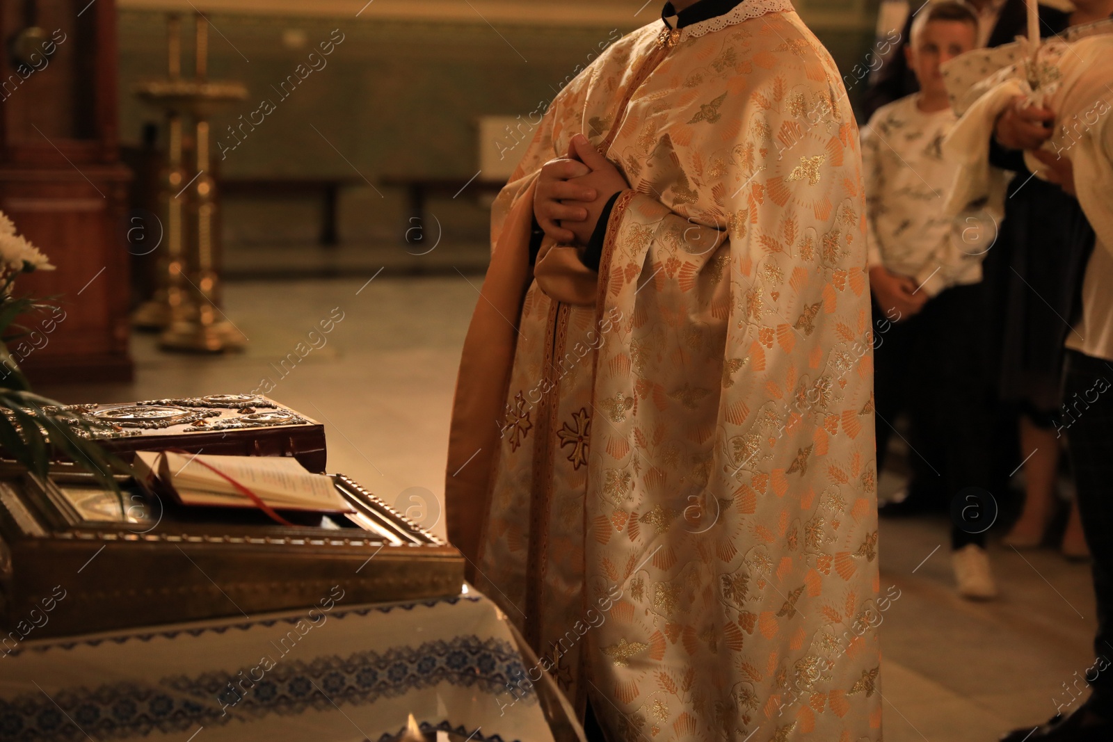 Photo of Stryi, Ukraine - September 11, 2022: Priest conducting baptism ceremony near altar in Assumption of Blessed Virgin Mary cathedral, closeup