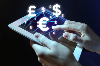 Image of Fintech concept. Woman using tablet on dark background, closeup