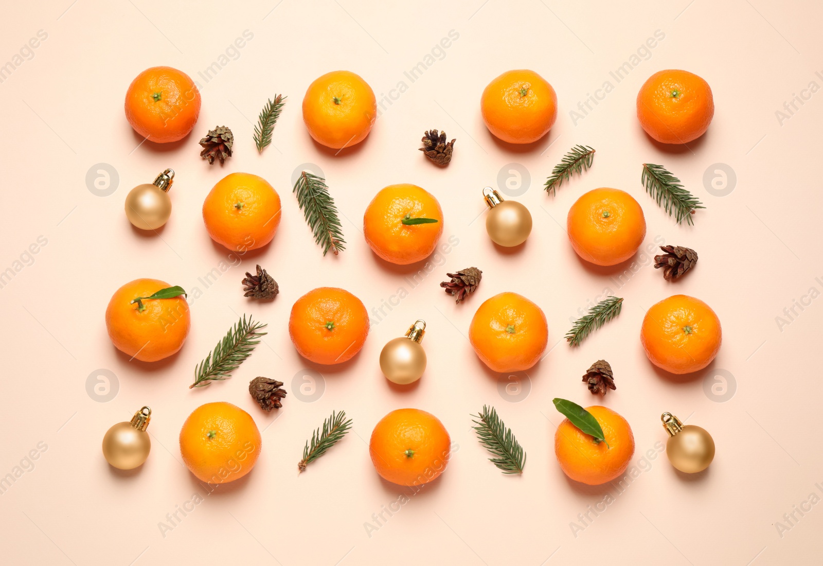 Photo of Composition with Christmas balls and tangerines on beige background, flat lay