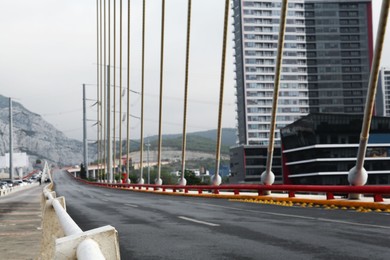 Blurred view of modern bridge near city