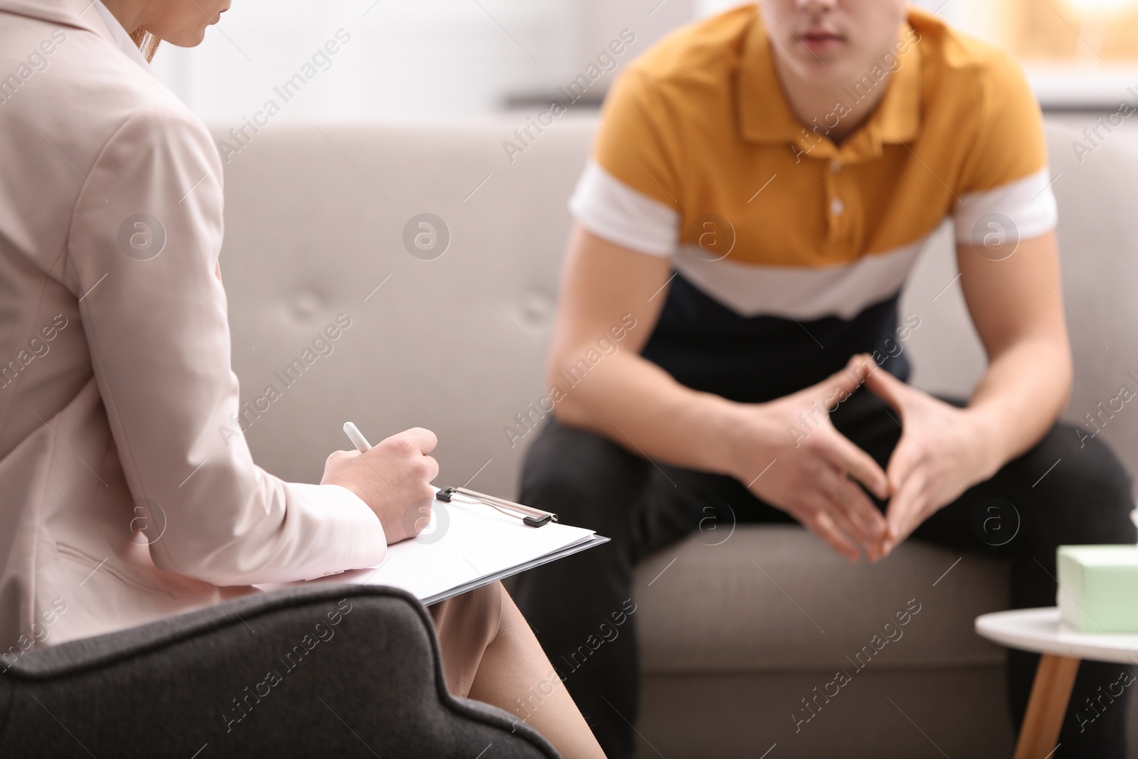 Photo of Psychotherapist working with young man in office, closeup