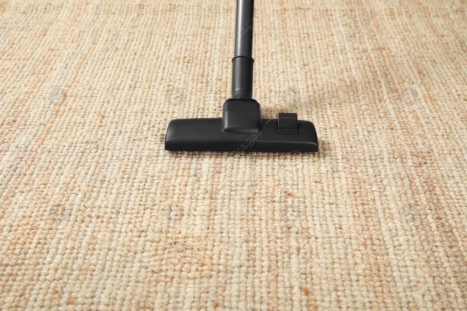 Photo of Removing dirt from beige carpet with modern vacuum cleaner. Space for text