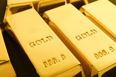 Photo of Shiny sleek gold bars as background, closeup