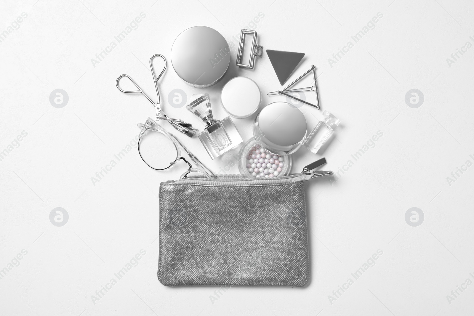 Photo of Cosmetic bag with makeup products and beauty accessories on white background, flat lay