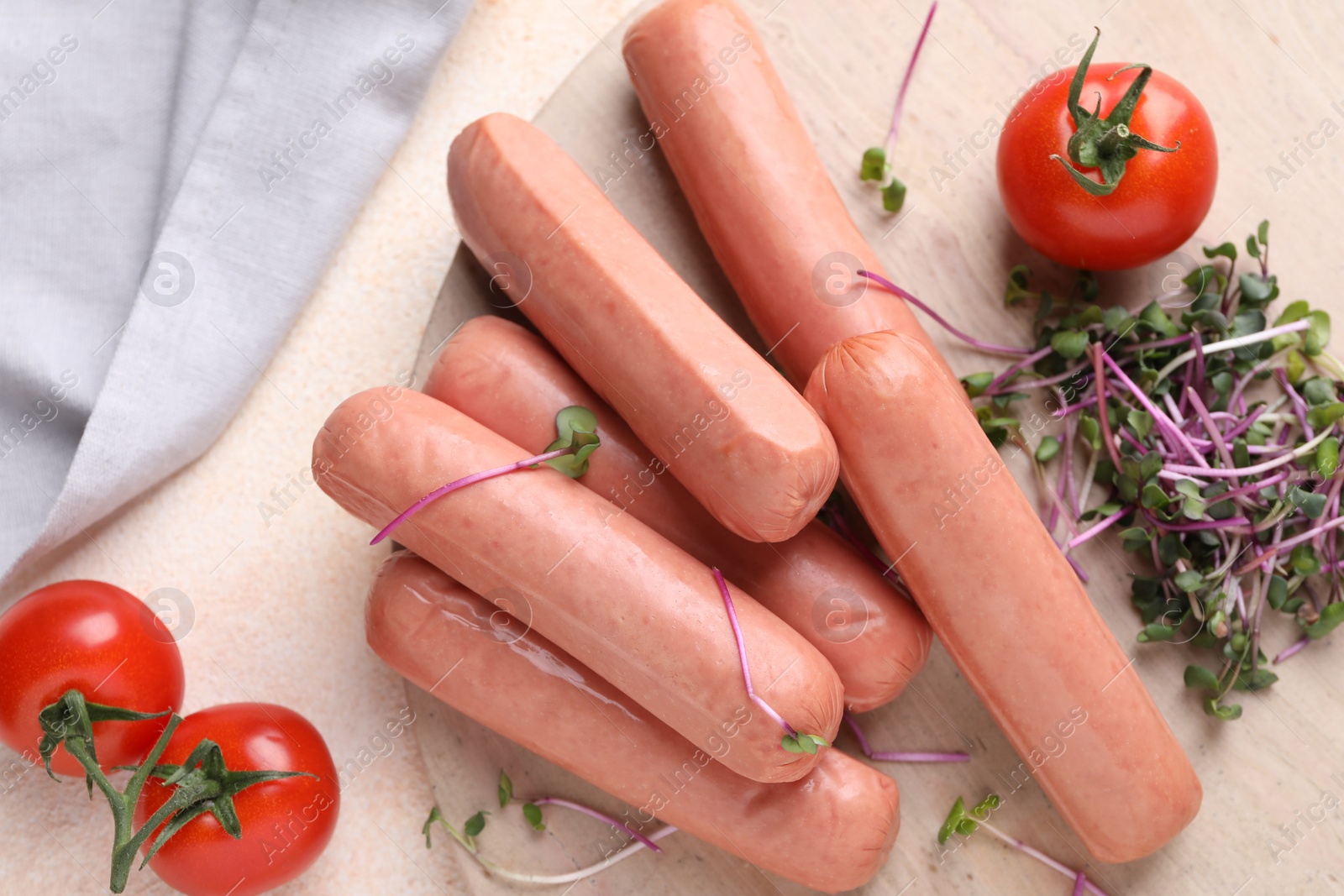 Photo of Tasty vegan sausages and products on beige table, flat lay