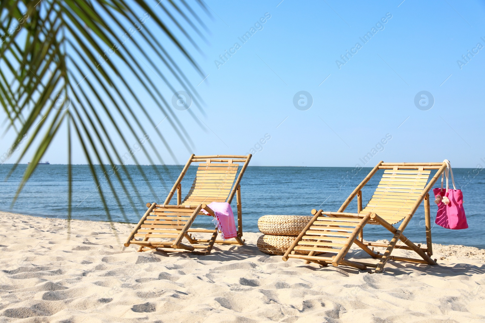 Photo of Wooden sunbeds and beach accessories on sandy shore