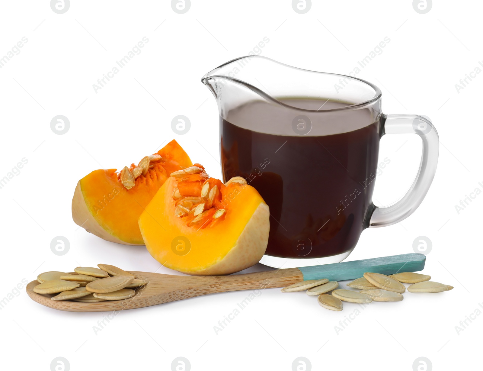 Photo of Fresh pumpkin seed oil in glass pitcher isolated on white