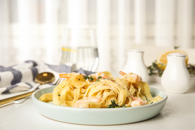 Photo of Delicious pasta with shrimps on white table indoors