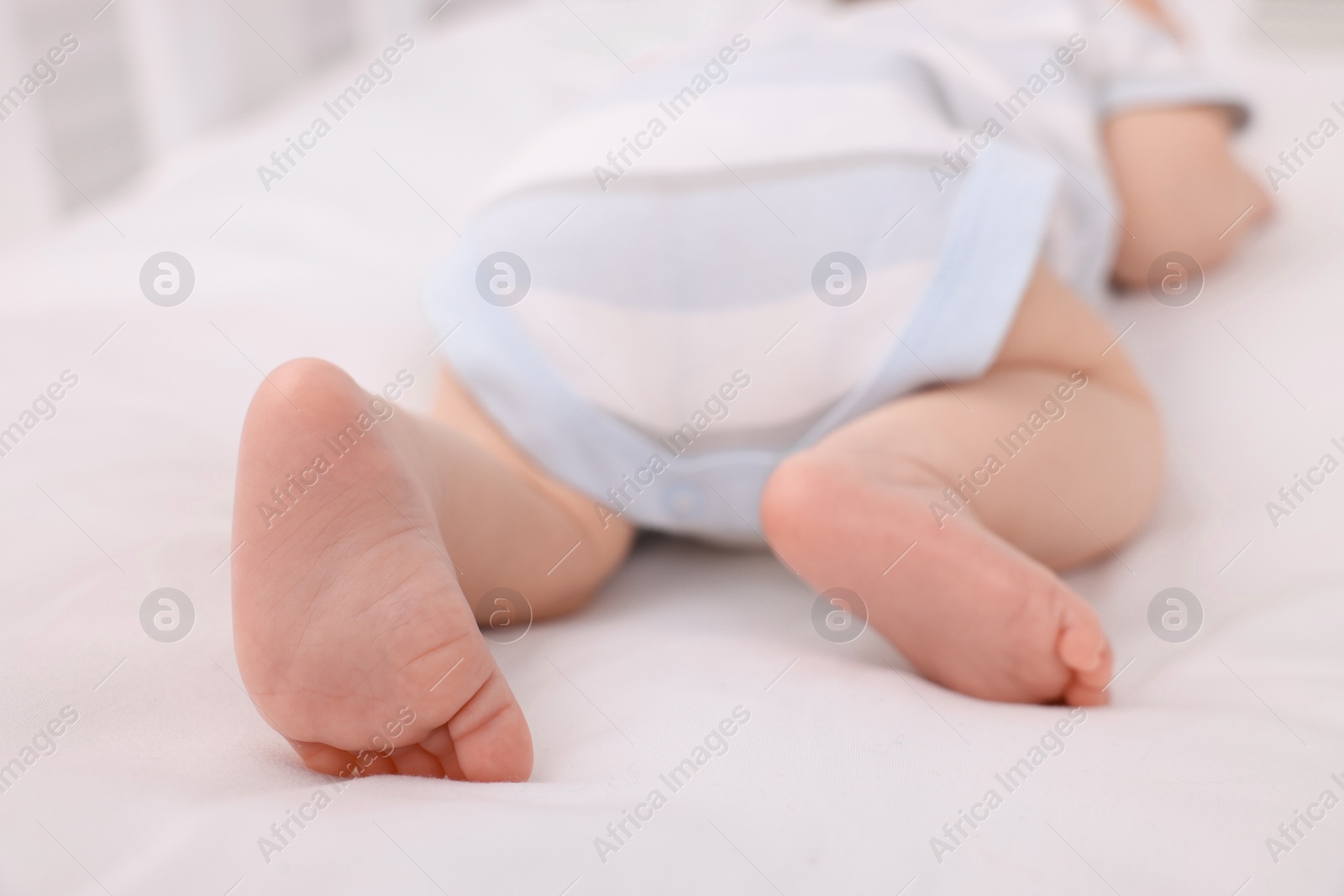 Photo of Newborn baby lying on white blanket, closeup