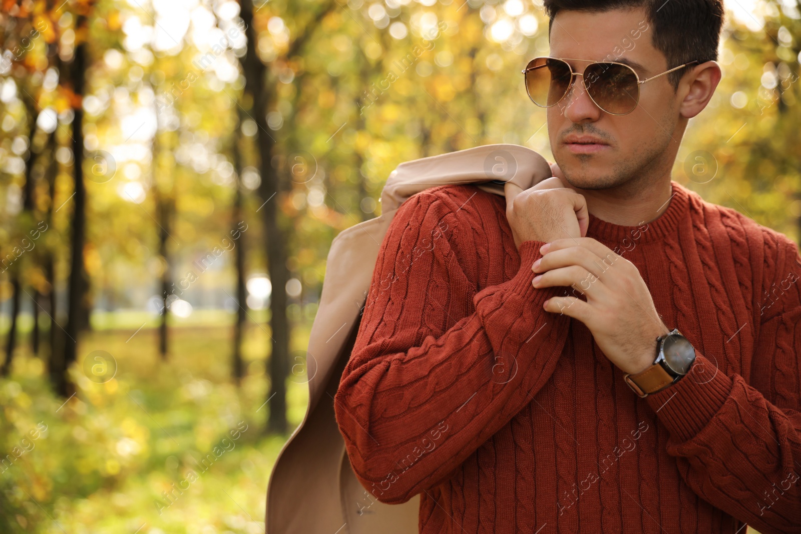 Photo of Handsome man walking in park on autumn day