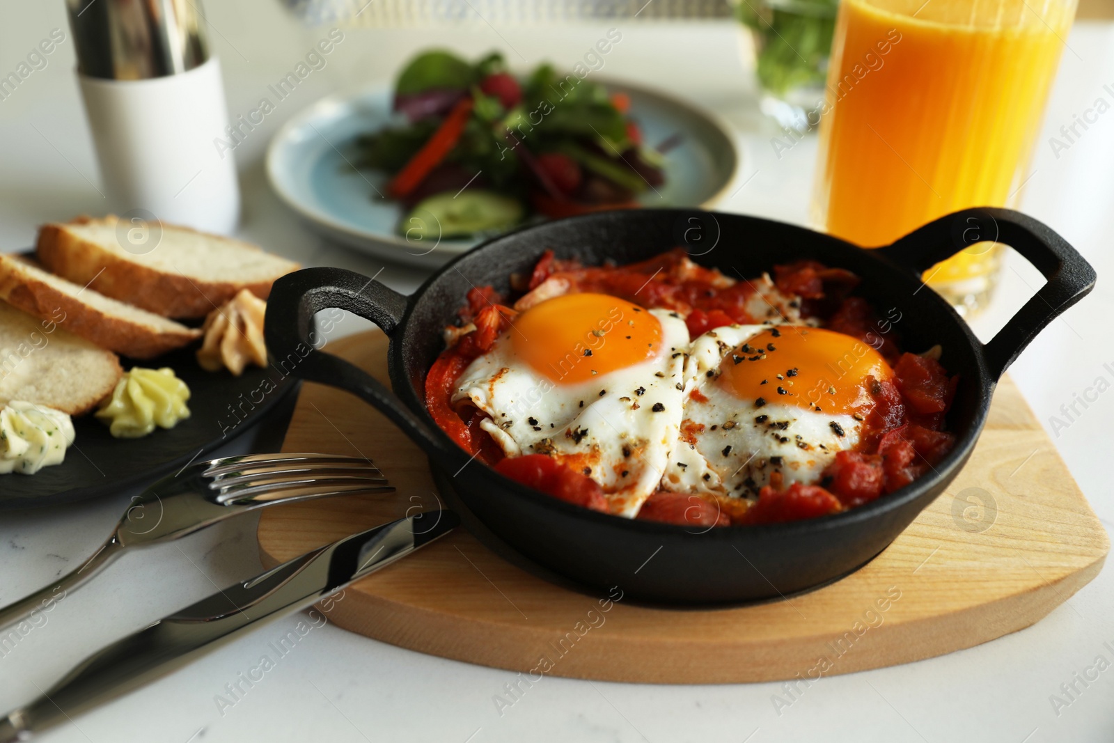 Photo of Tasty Shakshouka served on white table. Traditional Arabic dish