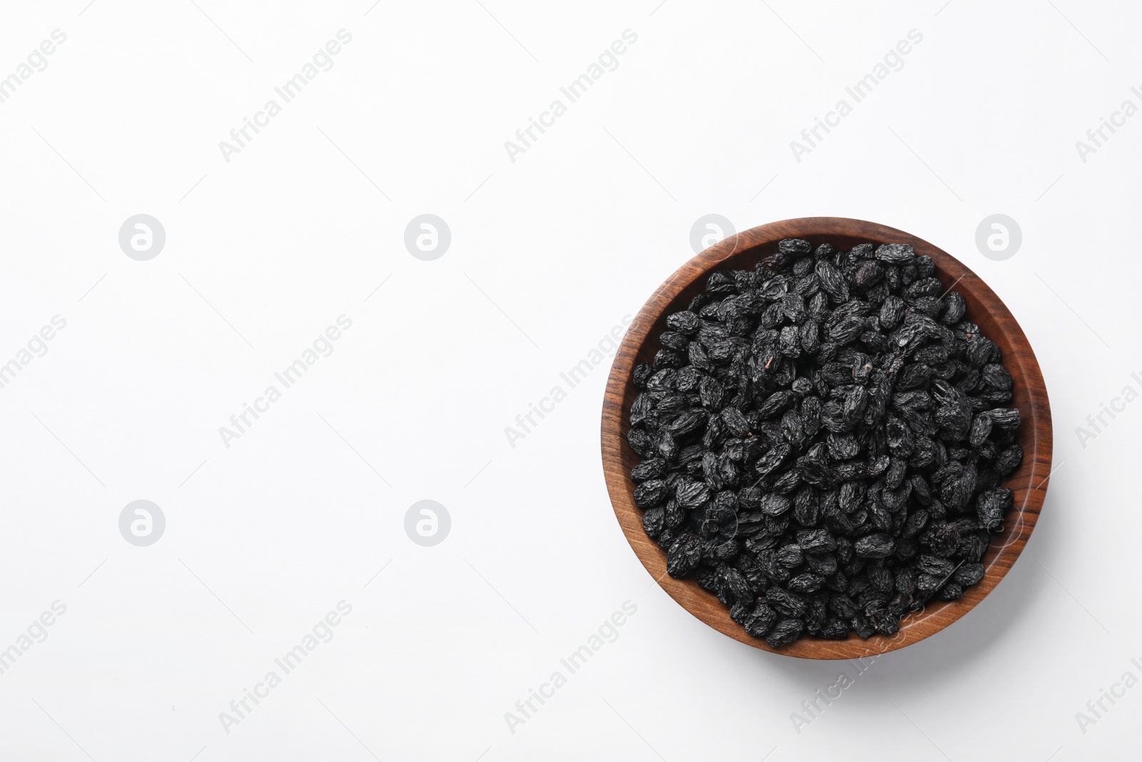 Photo of Bowl with raisins and space for text on white background, top view. Dried fruit as healthy snack