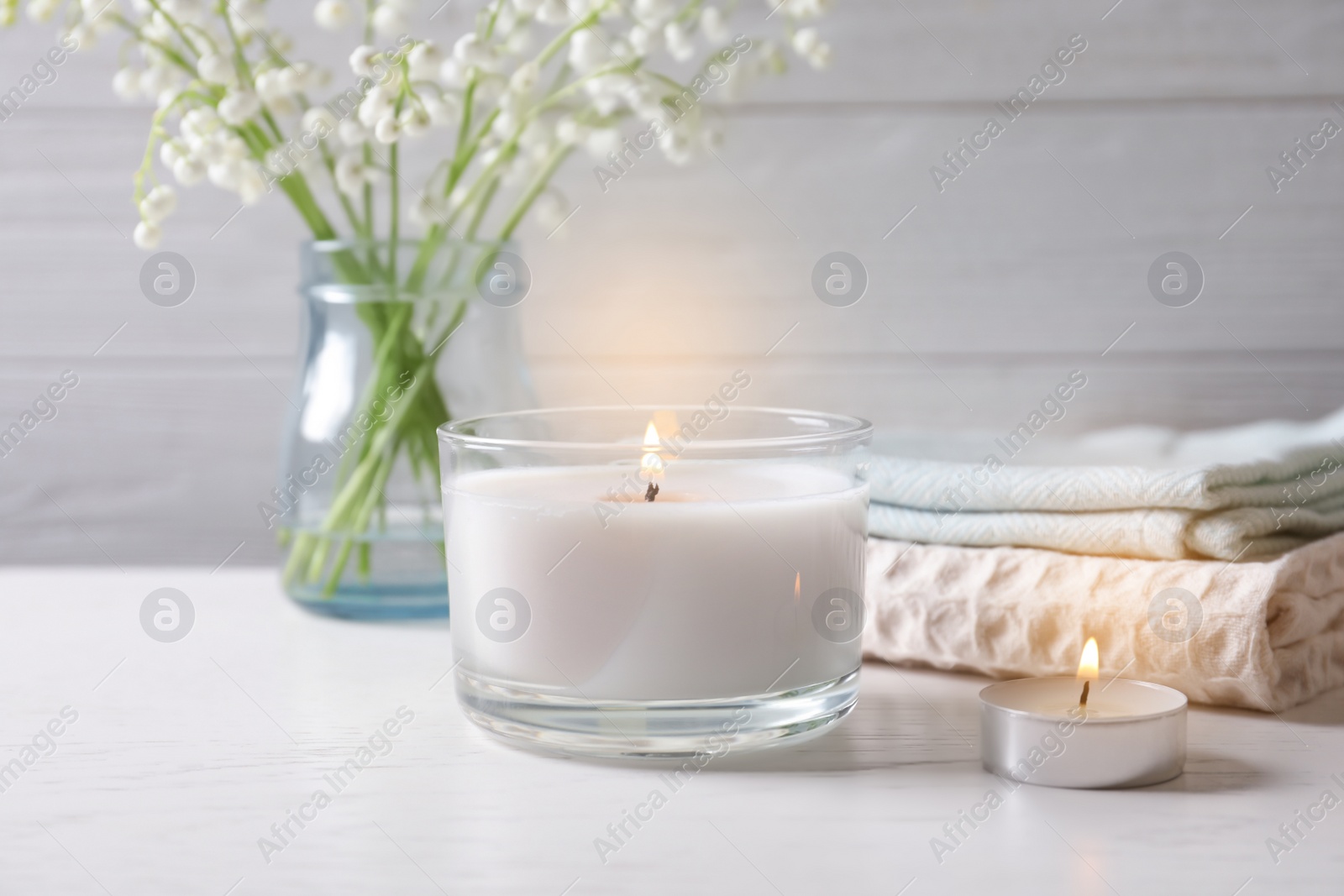 Photo of Burning wax candles of different shapes on table