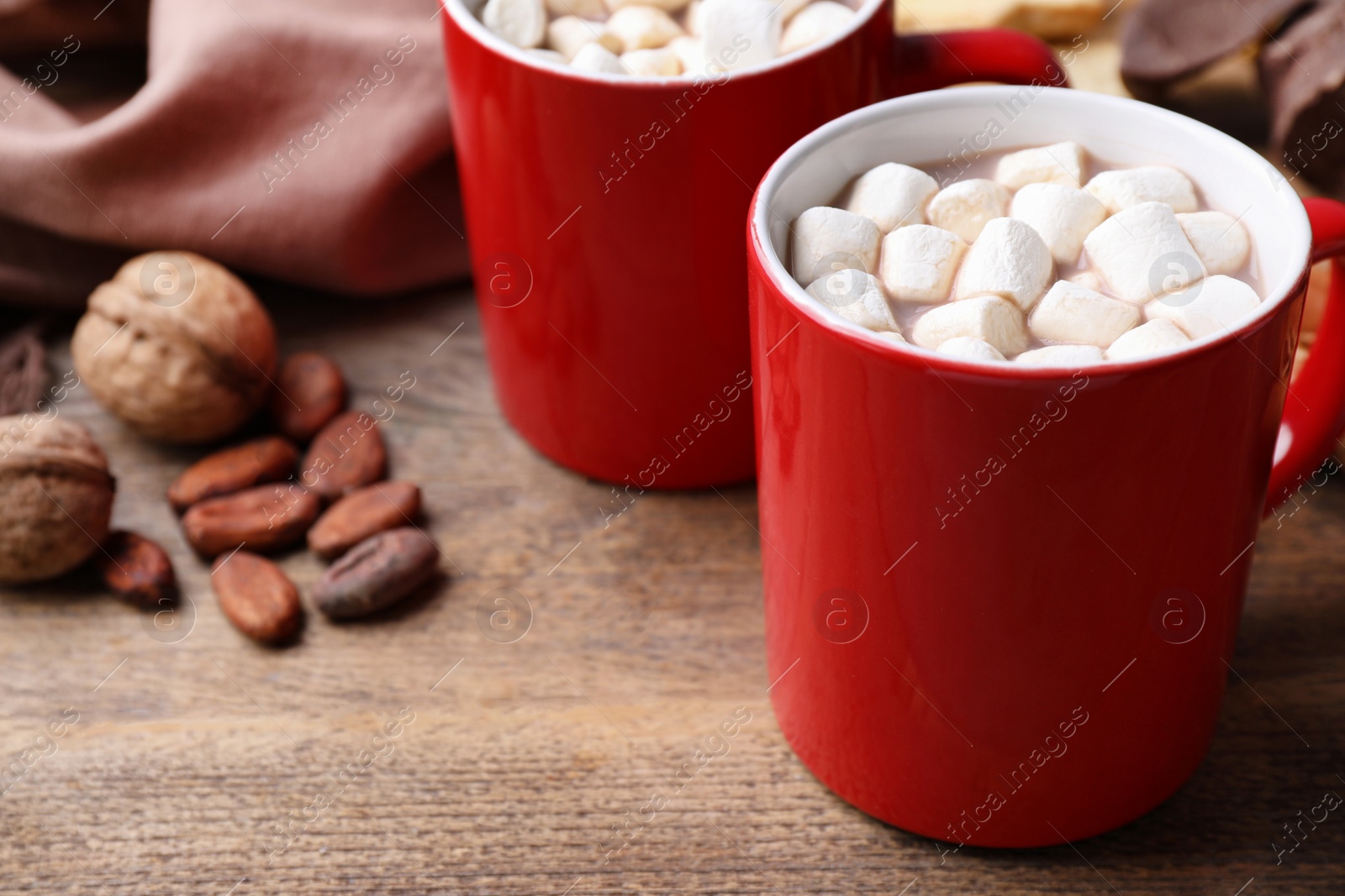 Photo of Composition of tasty cocoa with marshmallows in cups on wooden table