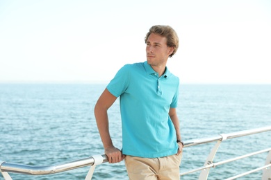 Photo of Portrait of handsome young man on sea pier