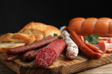 Photo of Different tasty sausages on wooden table, closeup