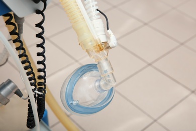 Oxygen mask as part of artificial lungs ventilation machine in surgery room, closeup. Space for text