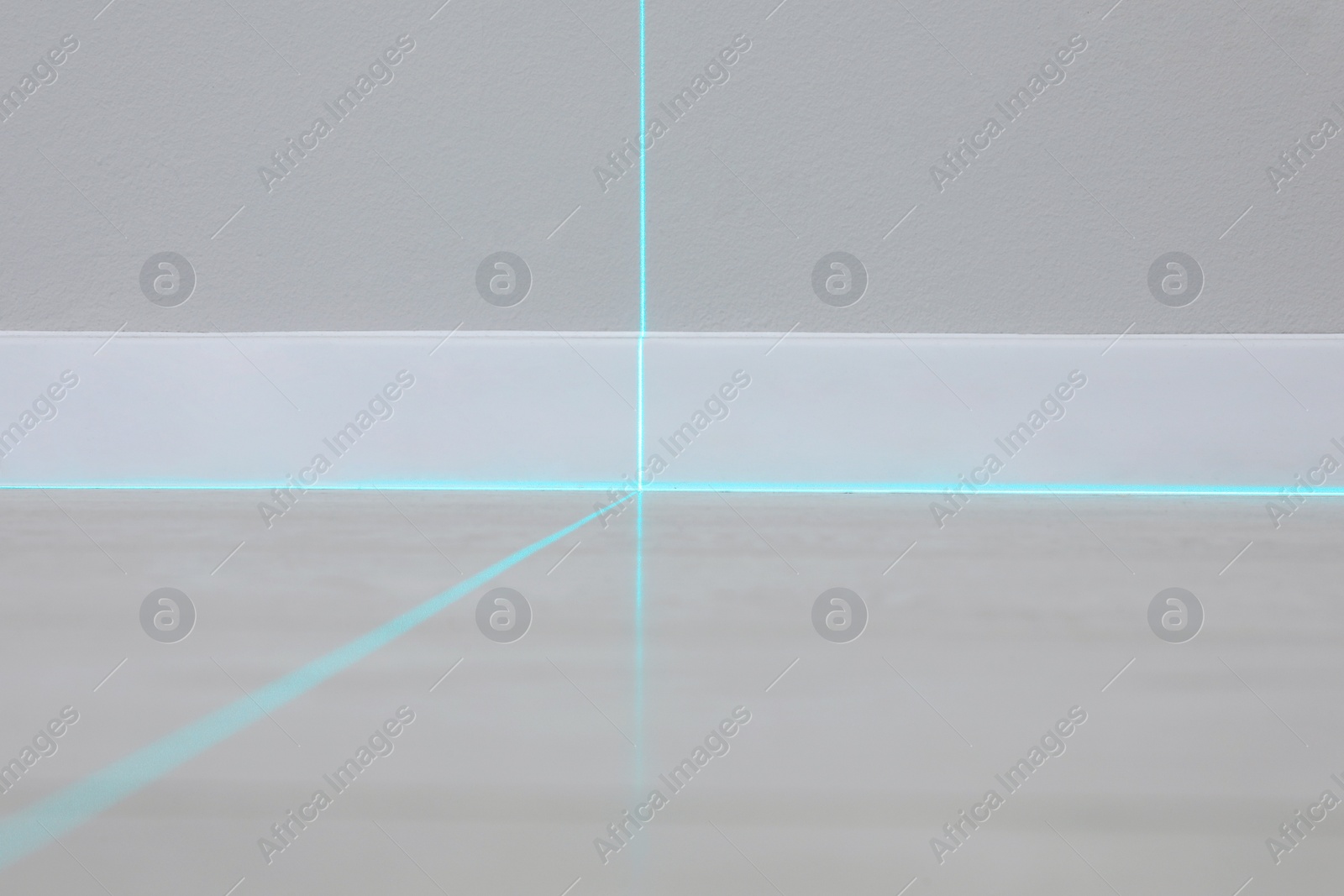 Photo of Cross lines of laser level on wall and floor indoors