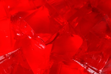 Delicious red jelly cubes as background, closeup