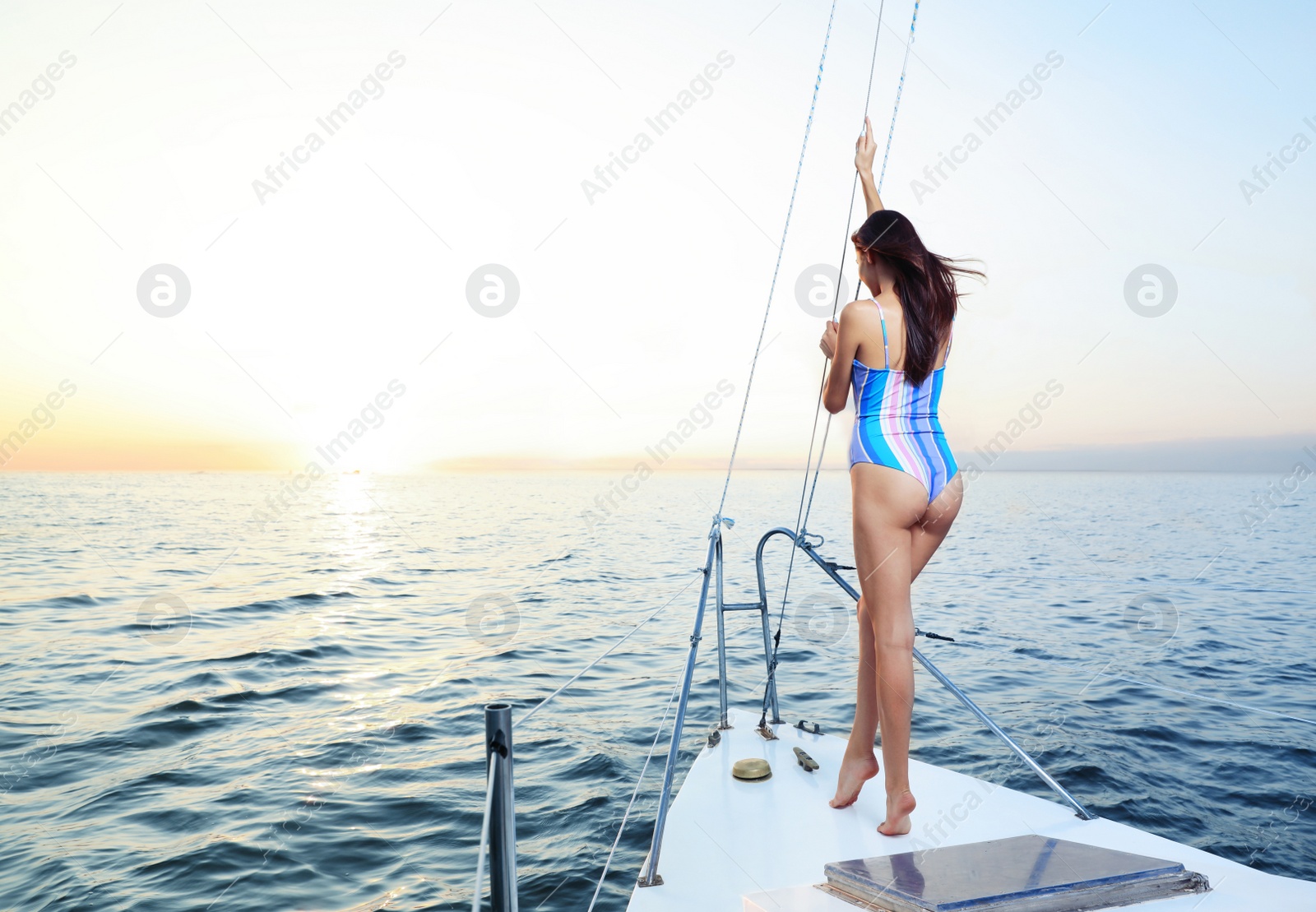 Photo of Beautiful woman in bikini enjoying sunset on yacht