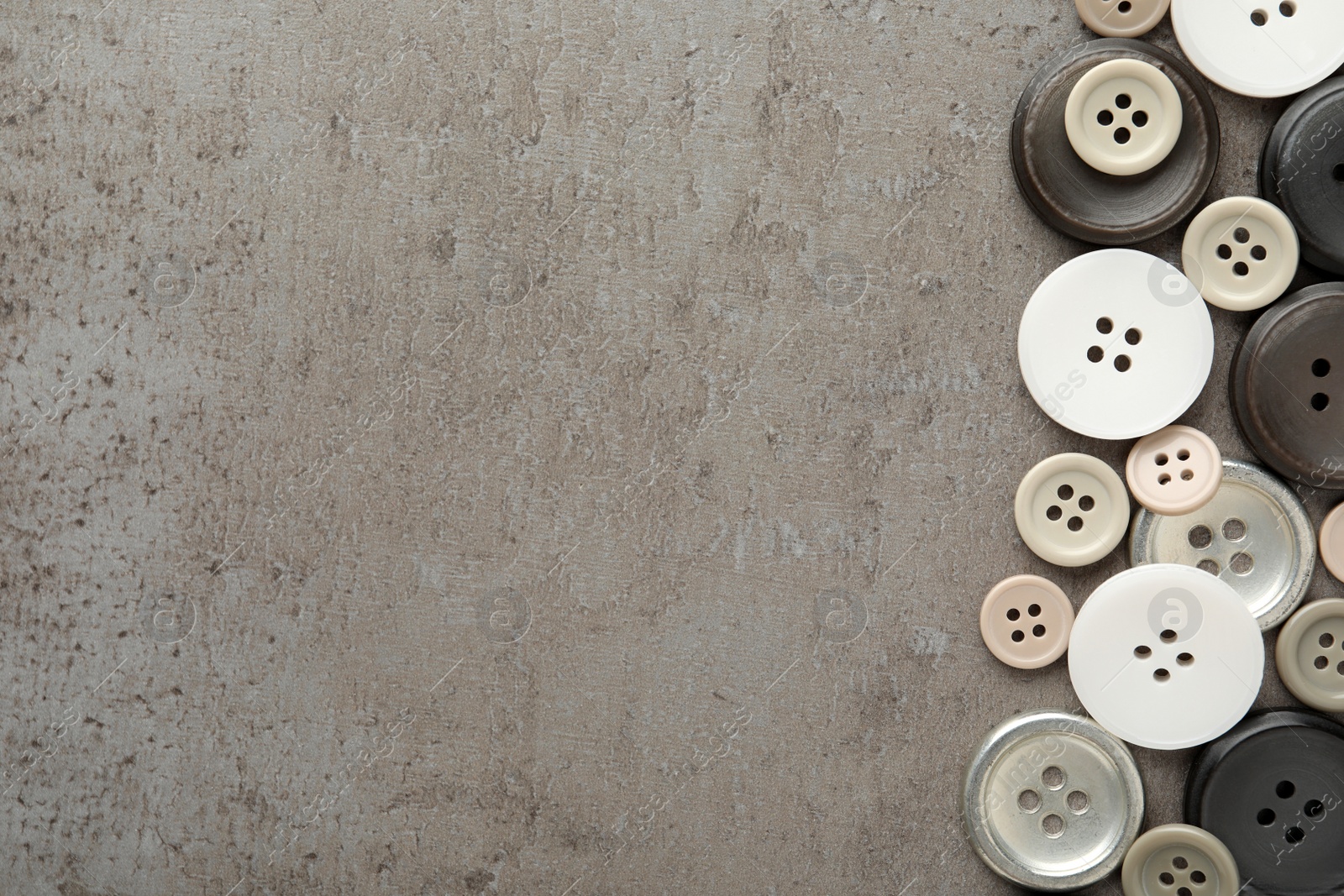 Photo of Many plastic sewing buttons on grey background, flat lay. Space for text