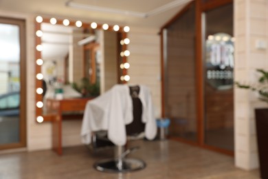 Photo of Blurred view of hairdressing salon with large mirror and chair