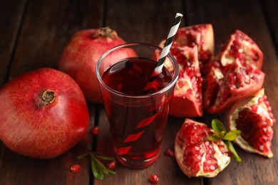 Photo of Pomegranate juice and fresh fruits on wooden table