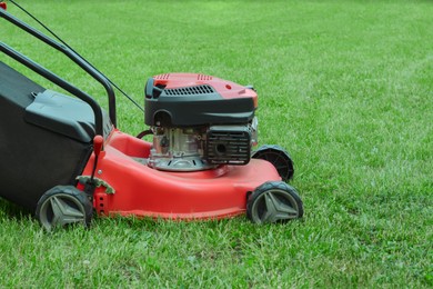 Photo of Modern garden lawn mower on green grass outdoors