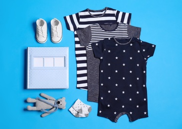 Photo of Flat lay composition with baby clothes and accessories on blue background