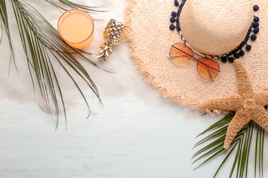 Photo of Flat lay composition with stylish hat and beach objects on wooden background