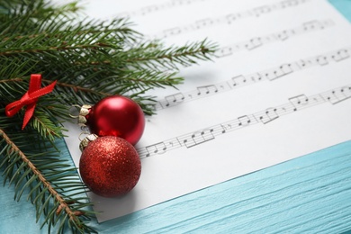 Photo of Christmas decorations and music sheet on blue wooden table, space for text