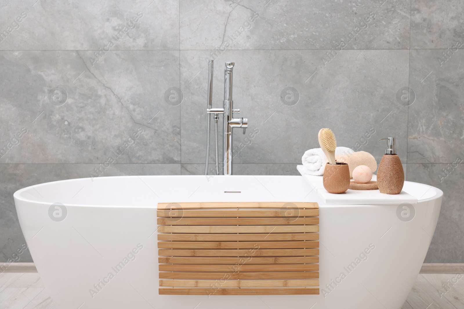 Photo of Different personal care products and accessories on bath tub in bathroom