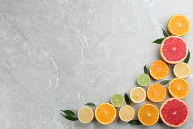 Photo of Flat lay composition with tangerines and different citrus fruits on grey marble background. Space for text