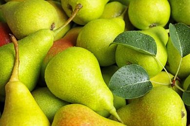 Photo of Fresh ripe pears with leaves as background