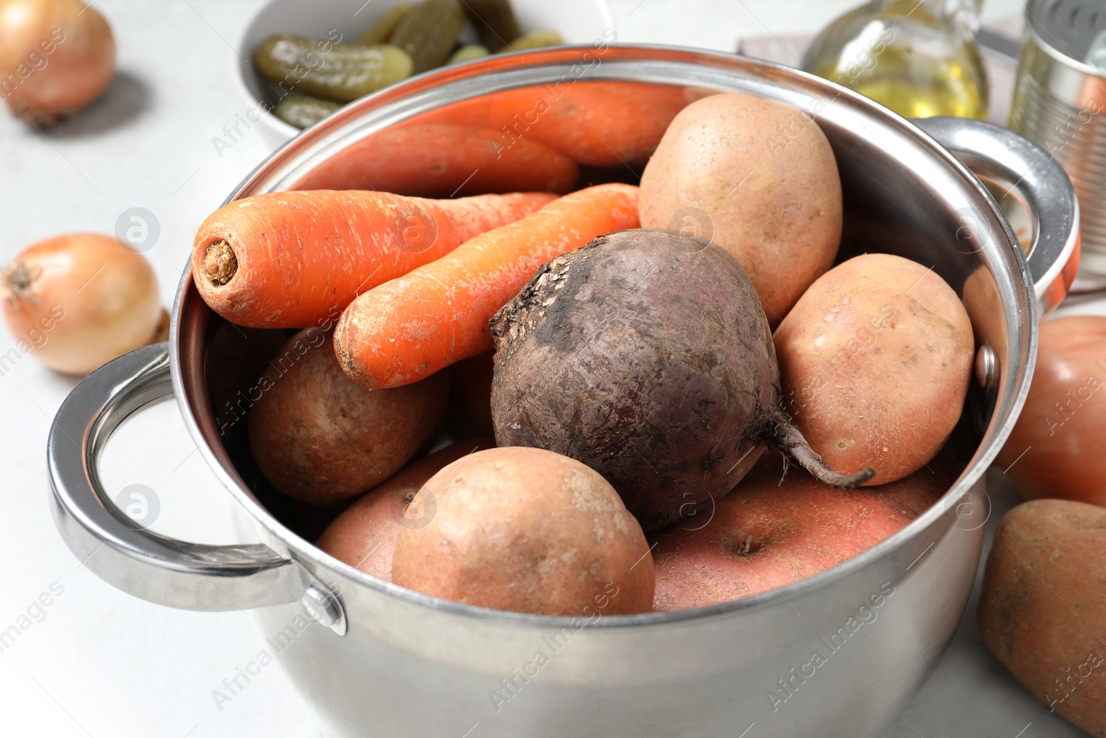 Photo of Pot with fresh vegetables at table, closeup. Cooking vinaigrette salad