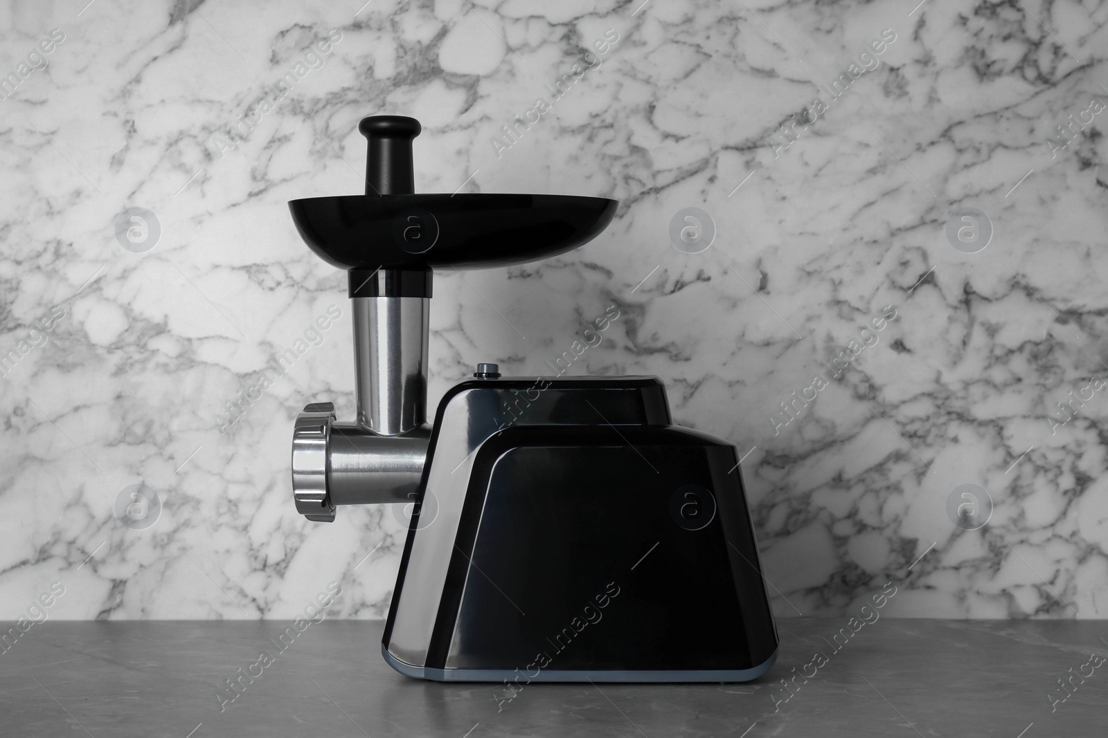 Photo of Modern electric meat grinder on grey table