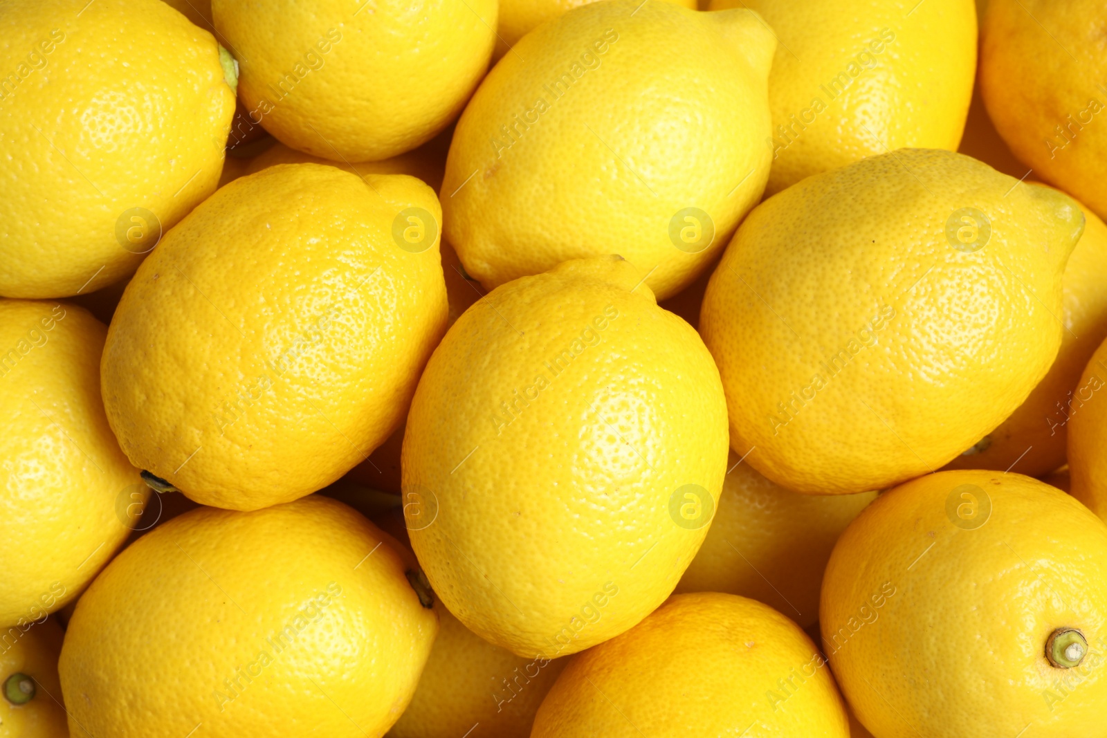 Photo of Many fresh ripe lemons as background, top view