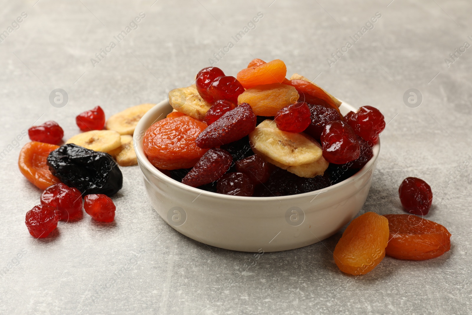 Photo of Mix of delicious dried fruits on grey table