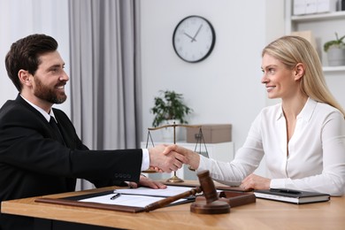 Lawyer shaking hands with client in office