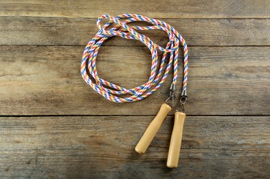 Skipping rope on wooden table, top view. Sports equipment