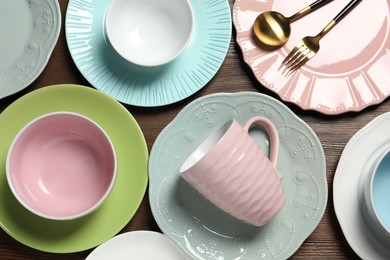 Photo of Beautiful ceramic dishware, cup and cutlery on wooden table, flat lay