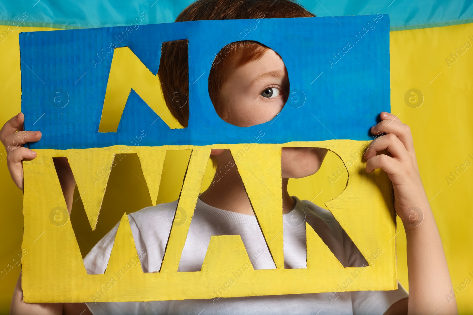 Photo of Boy holding poster No War against Ukrainian flag