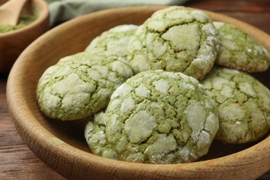 Photo of Bowl with tasty matcha cookies on wooden table, closeup