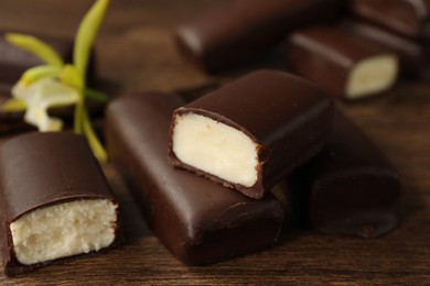 Photo of Glazed curd cheese bars on wooden table, closeup