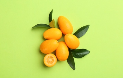 Photo of Fresh ripe kumquats on light green background, flat lay