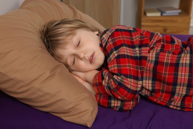 Little boy snoring while sleeping in bed at home