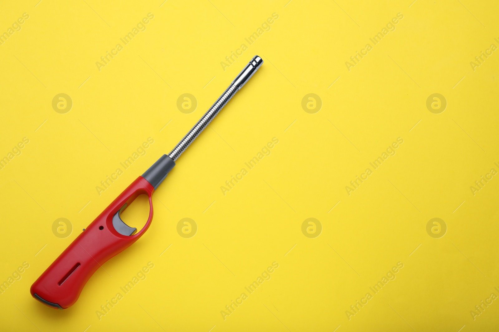 Photo of One gas lighter on yellow background, top view. Space for text