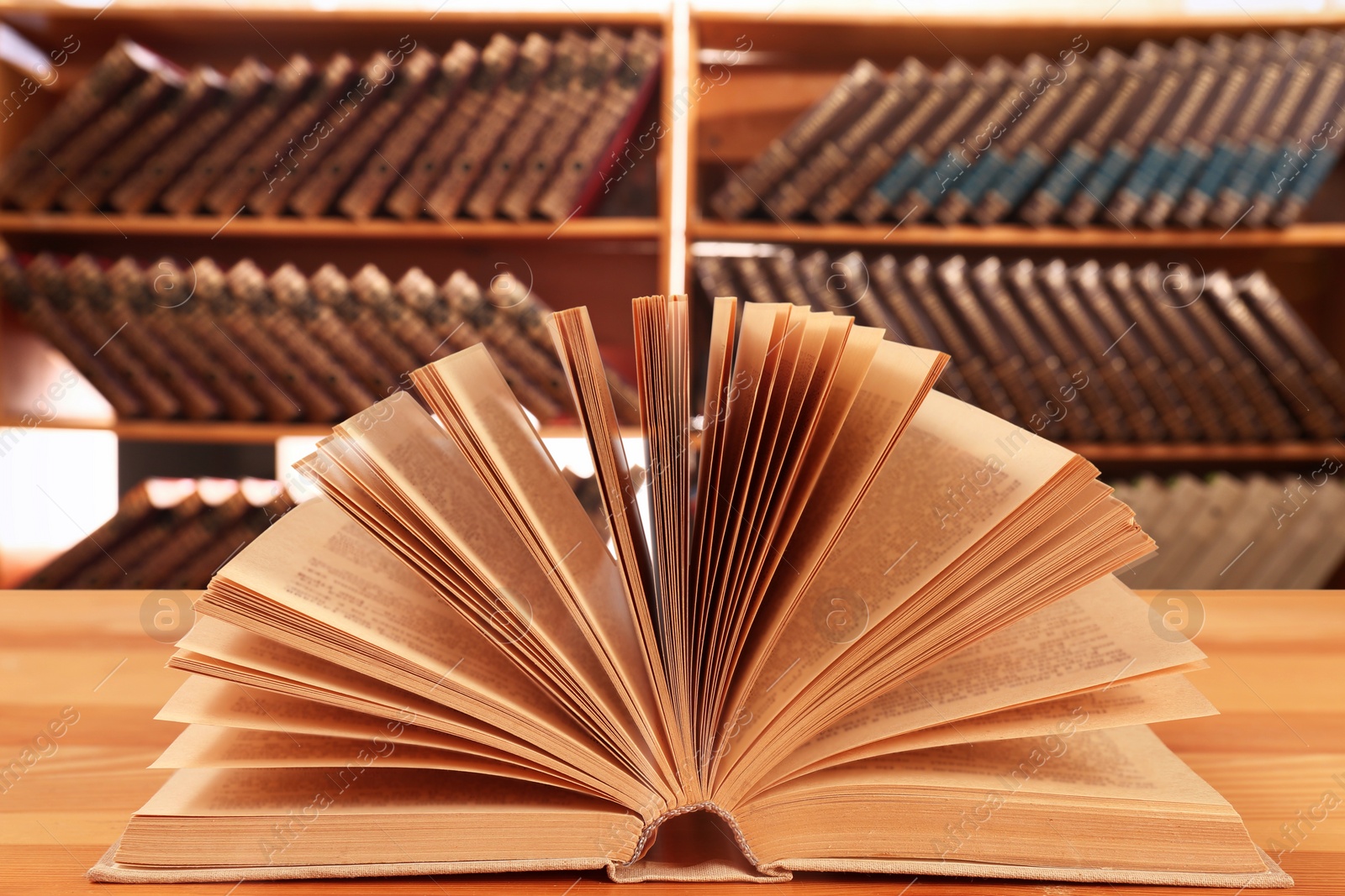 Image of Open book on wooden table in library