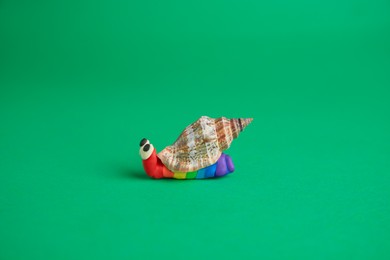 Photo of Snail made from plasticine on green background. Children's handmade ideas
